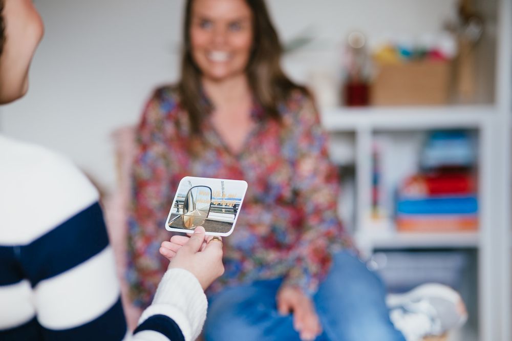 Meisje leest pubercoachkaart en lacht in kinderpraktijk Mindful Meiden.